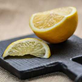 Zitronenscheiben auf Schneidebrett für fruchtigen Badreiniger